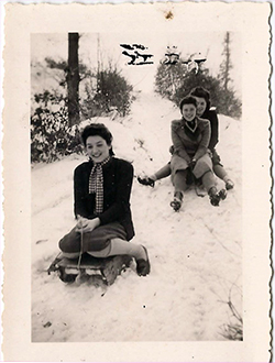 Photo de trois jeunes femmes descendant une pente neigeuse en traineau